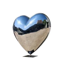 Heart-shaped mirror polished stainless steel sculpture placed outdoors