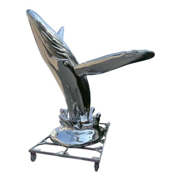 A stainless steel sculpture of a whale interacting with a little girl, polished to a mirror finish, suitable for outdoor display.