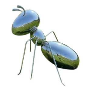 Polished stainless steel ant sculpture displayed outdoors on a grassy field
