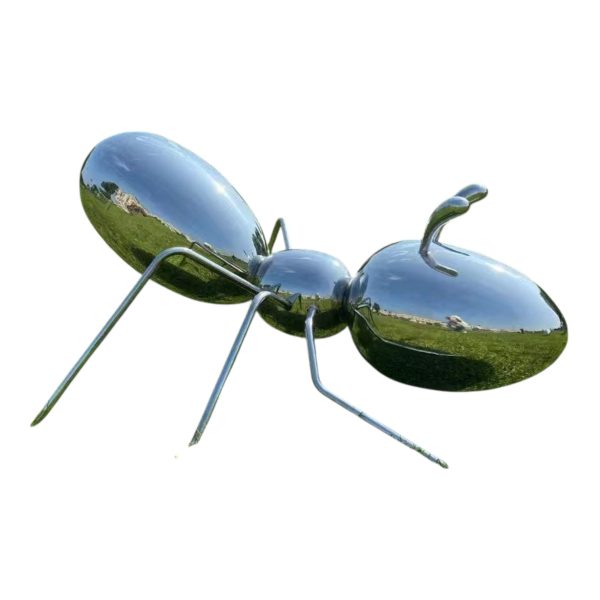 Polished stainless steel ant sculpture displayed outdoors on a grassy field