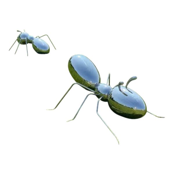 Polished stainless steel ant sculpture displayed outdoors on a grassy field
